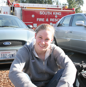 Megan Jendrick sitting outside the King County Aquatic Center on the first day of Spring Nationals due to a fire inside the pool.