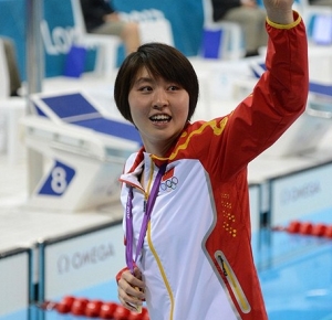 Liuyang Jiao (CHN) waves with her gold medal during the women's 200m butterfly final during the London 2012 Olympic Games at Aquatics Centre.
