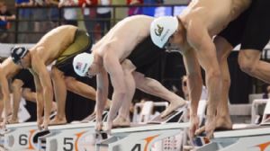 Matt Grevers (5) and Jimmy Feigen (4) and Nathan Adrian (3) get set for the start of the men's 50 meter freestyle final during the Austin Grand Prix at the Texas Swimming Center.