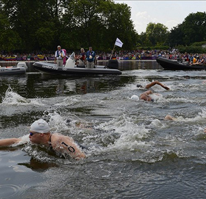 Andreas Waschburger (GER, 10) and the rest of the swimmers in the field past the start/finish area during a lap in the men's open water 10km swim during the London 2012 Olympic Games at Hyde Park.
