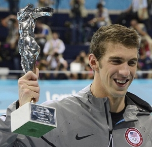 Michael Phelps (USA) holds up a trophy that reads "greatest Olympic athlete of all time" after the men's 4x100m medley relay final during the London 2012 Olympic Games at Aquatics Centre.