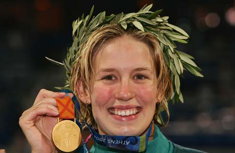 ATHENS - AUGUST 19: Gold medalist Jodie Henry of Australia celebrates on the podium during the medal ceremony of the of he women's swimming 100 metre freestyle competition on August 19, 2004 during the Athens 2004 Summer Olympic Games at the Main Pool of the Olympic Sports Complex Aquatic Centre in Athens, Greece. Inge De Bruijn of the Netherlands came second and Natalie Coughlin of USA came third. (Photo by Adam Pretty/Getty Images)