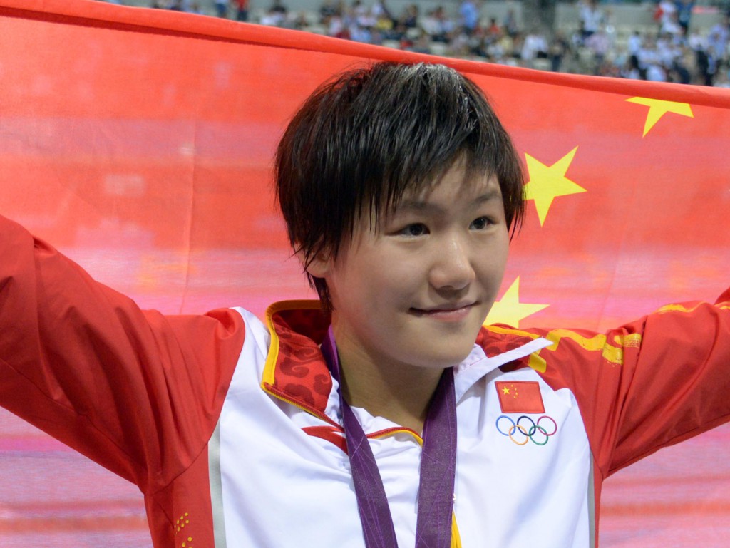 Jul 31, 2012; London, United Kingdom; Ye Shiwen (CHN) poses with her gold medal and a China flag after winning the women's 200m individual medley finals during the London 2012 Olympic Games at Aquatics Centre. Mandatory Credit: Kirby Lee-USA TODAY Sports