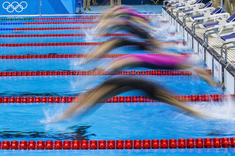 Swimmer start for the Backstroke leg in the women's 4x100m Medley Relay Heat 2