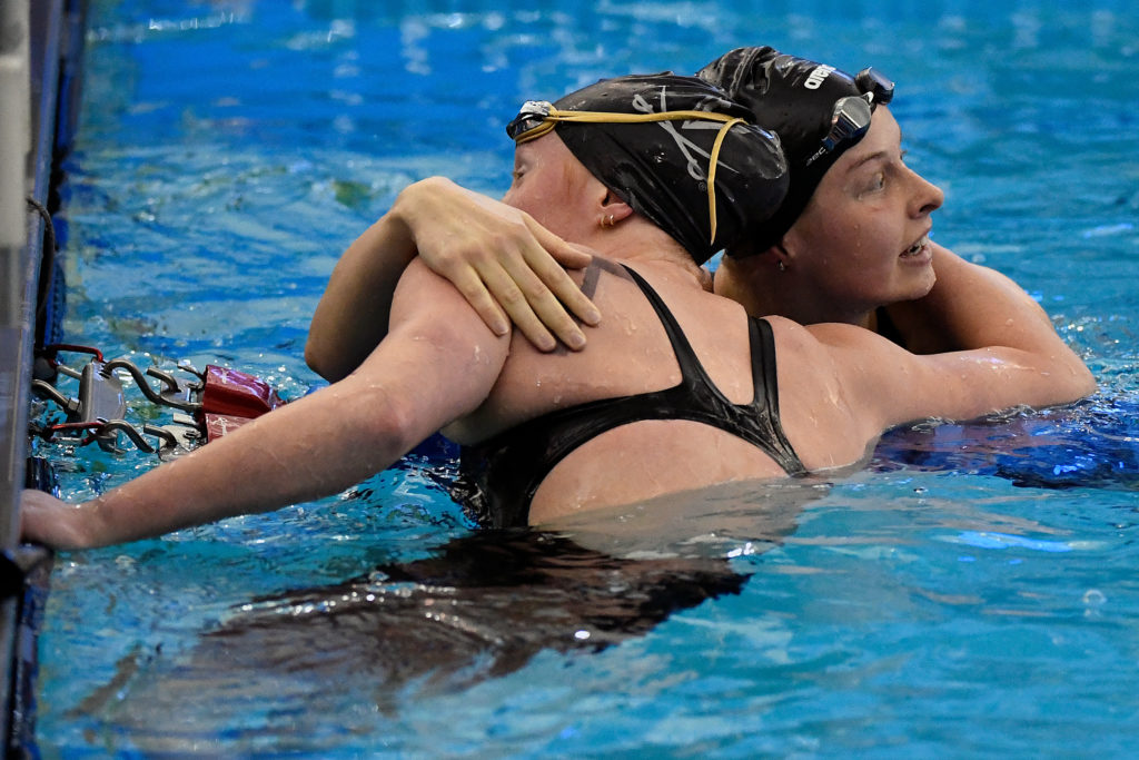 GREENSBORO, NORTH CAROLINA - MARCH 20: Sophie Hansson of the NC State Wolfpack hugs Ella Nelson of the Virginia Cavaliers after winning the 200 Yard Breaststroke during the Division I Women’s Swimming & Diving Championships held at the Greensboro Aquatic Center on March 20, 2021 in Greensboro, North Carolina. (Photo by Mike Comer/NCAA Photos via Getty Images)
